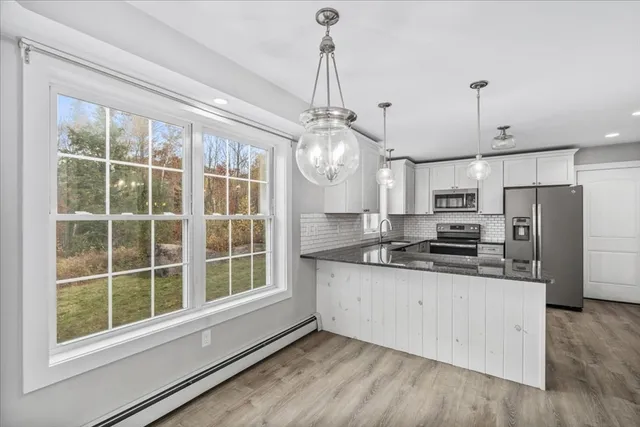a kitchen with stainless steel appliances a stove a refrigerator and a sink