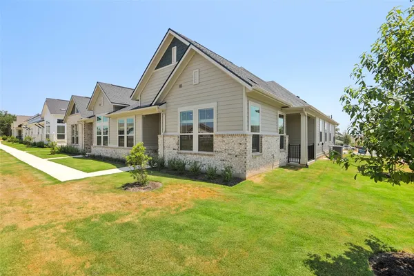 a view of a house with a big yard and large trees