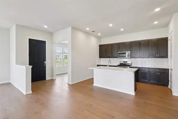 a kitchen with a sink a counter space and wooden floor