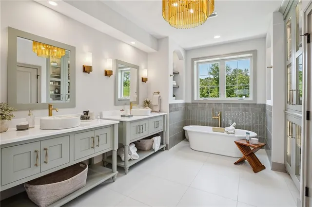 a bathroom with a double vanity sink a mirror and a bathtub