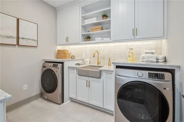 a utility room with sink dryer and washer