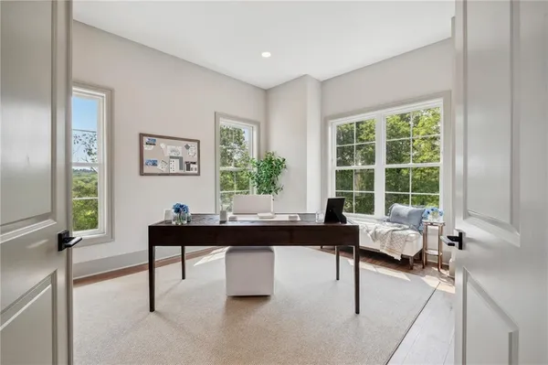a living room with furniture a large window and a potted plant