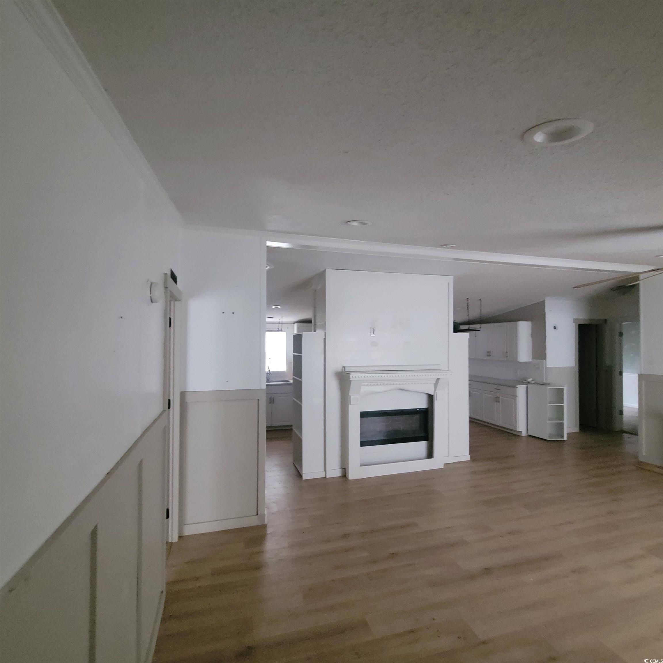 1781 Dixie Court Loris, SC 29569 - Photo 5 of 18 Unfurnished living room featuring light wood-style flooring and a glass covered fireplace