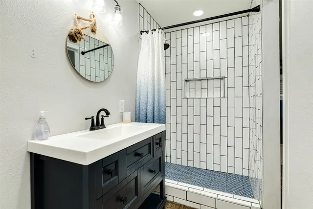 a bathroom with a sink a mirror and a shower