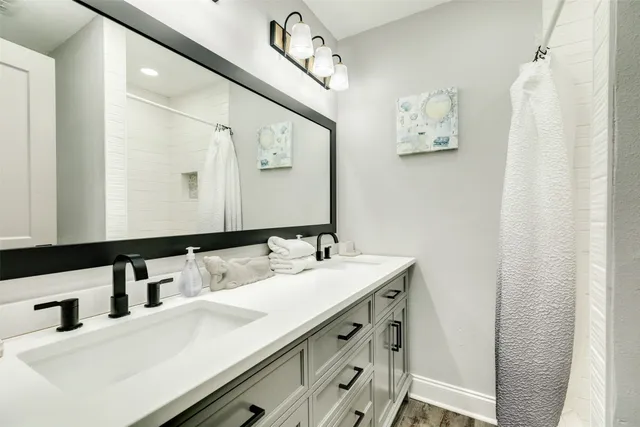 a bathroom with a double vanity sink and a mirror