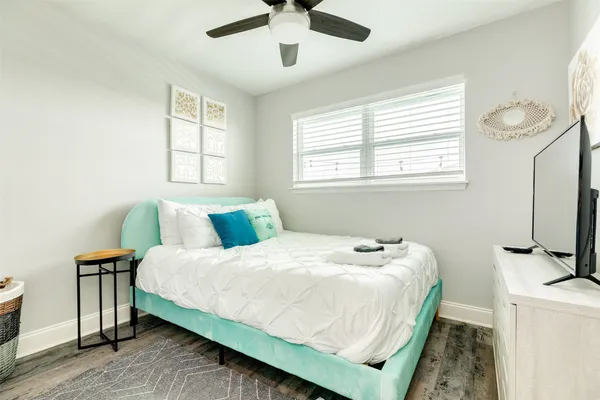 a bedroom with a bed and a flat tv screen on dresser