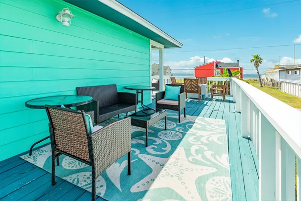 a balcony with furniture and a wooden floor