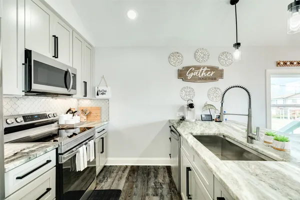 a kitchen with a sink stove and microwave