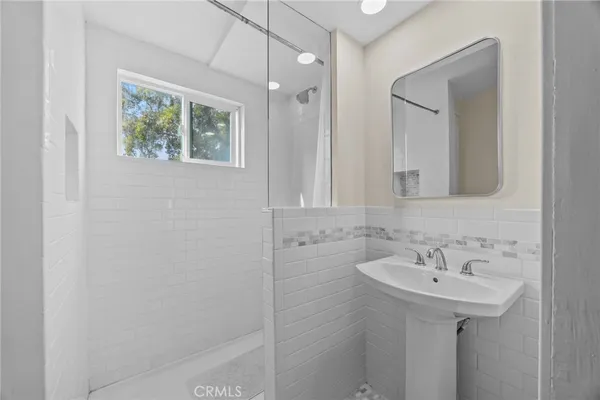 a bathroom with a sink a mirror and a shower
