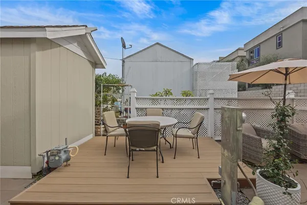 a roof deck with table and chairs under an umbrella