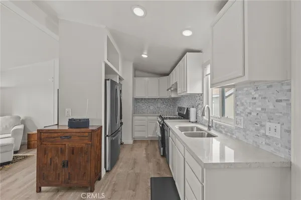 a kitchen with a sink appliances and cabinets