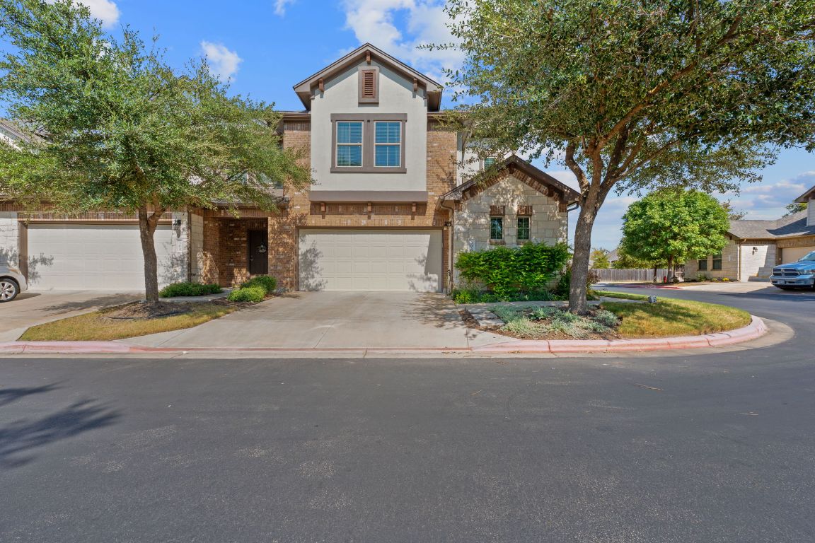 a view of a house with a yard and large tree