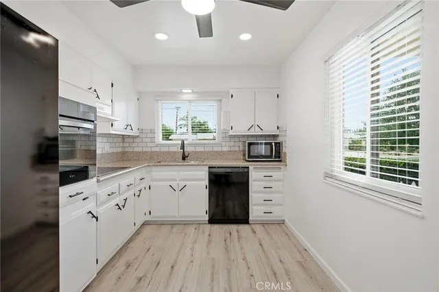 a kitchen with cabinets appliances and a window