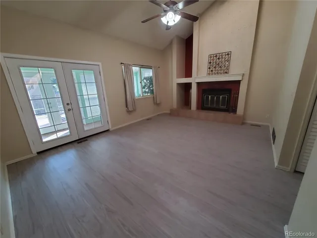 an empty room with windows cabinet and fireplace