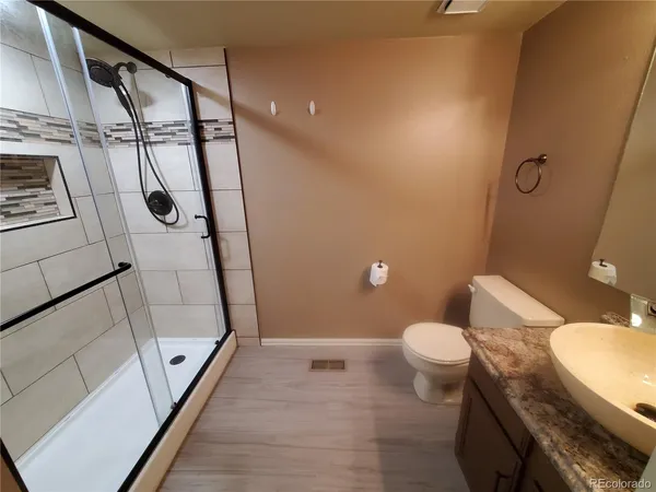 a bathroom with a sink a toilet and shower