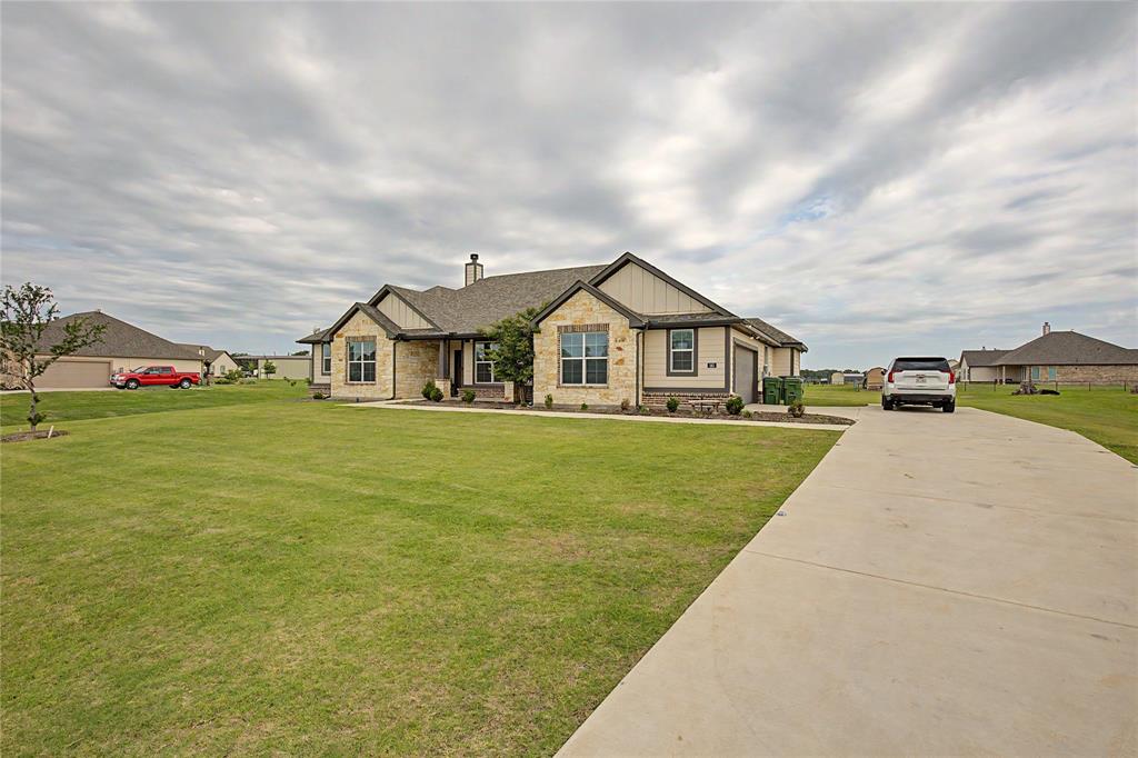 185 Chester Road Springtown, TX 76082 - Photo 7 of 40 Stone and siding exterior with a concrete driveway, established lawn, and landscaping
