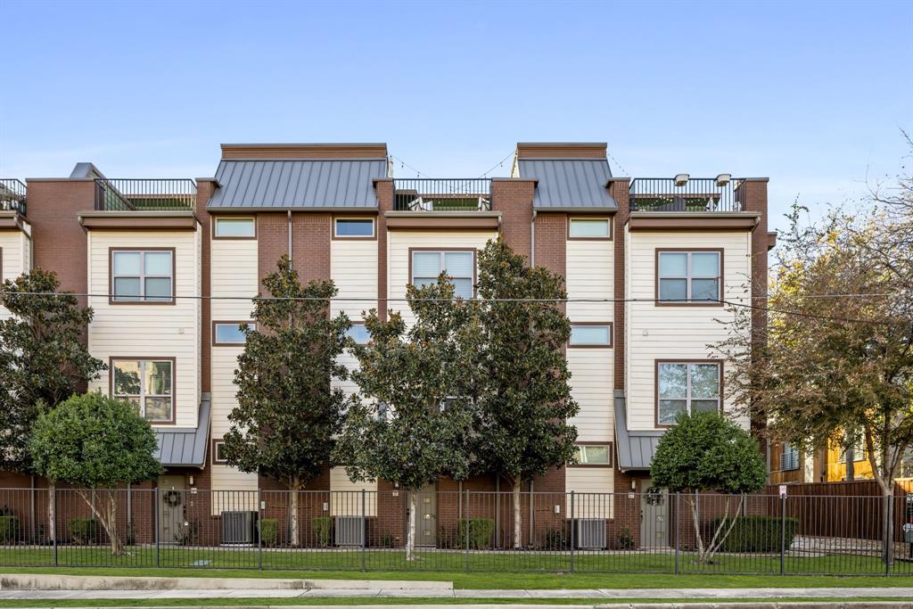 a front view of residential houses with yard and trees