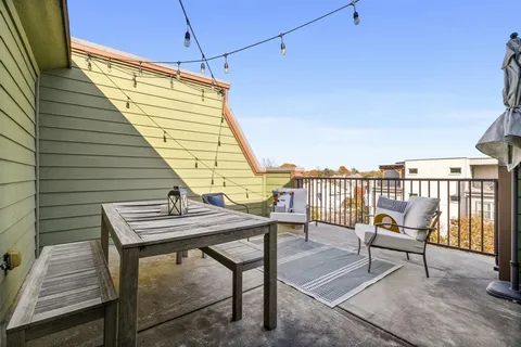 a balcony with wooden floor outdoor seating and deck