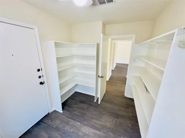 a view of a livingroom with wooden floor and a ceiling fan