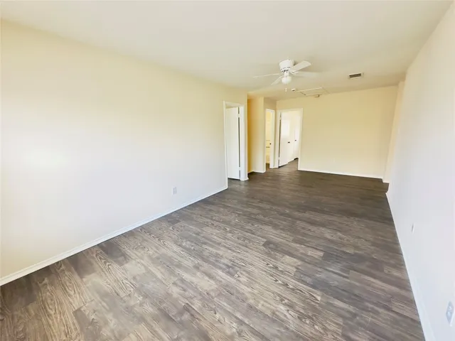 an empty room with wooden floor and mirror