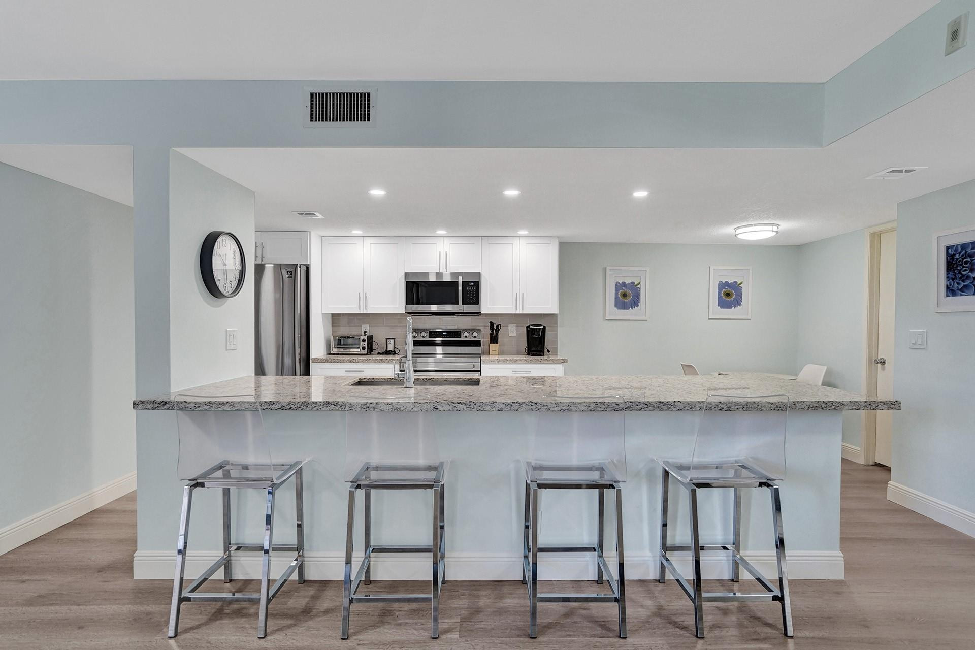 955 Dotterel Road, Unit 2304 Delray Beach, FL 33444 - Photo 13 of 47 a large white kitchen with lots of counter space and window
