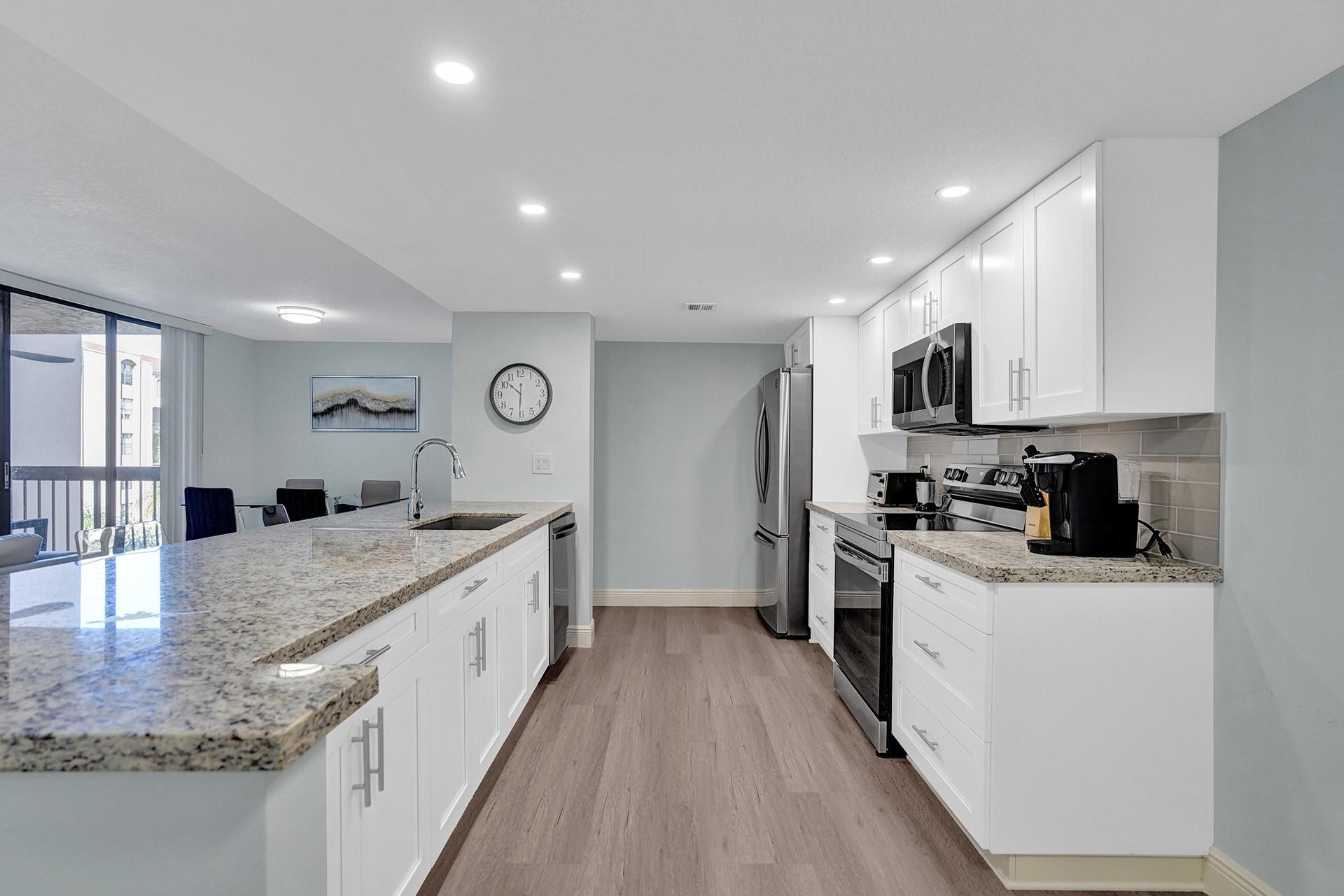 955 Dotterel Road, Unit 2304 Delray Beach, FL 33444 - Photo 31 of 47 a large kitchen with stainless steel appliances granite countertop a lot of counter space and wooden floor