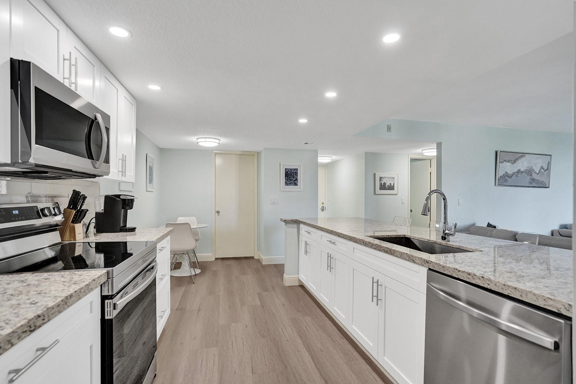 955 Dotterel Road, Unit 2304 Delray Beach, FL 33444 - Photo 39 of 47 a large kitchen with stainless steel appliances granite countertop a lot of counter space and wooden floor