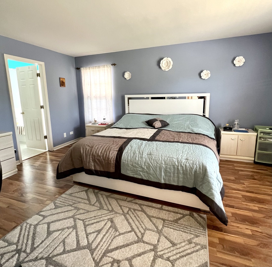 1800 Fulton Lane Sycamore, IL 60178 - Photo 30 of 48 a bedroom with a large bed and a wooden floor
