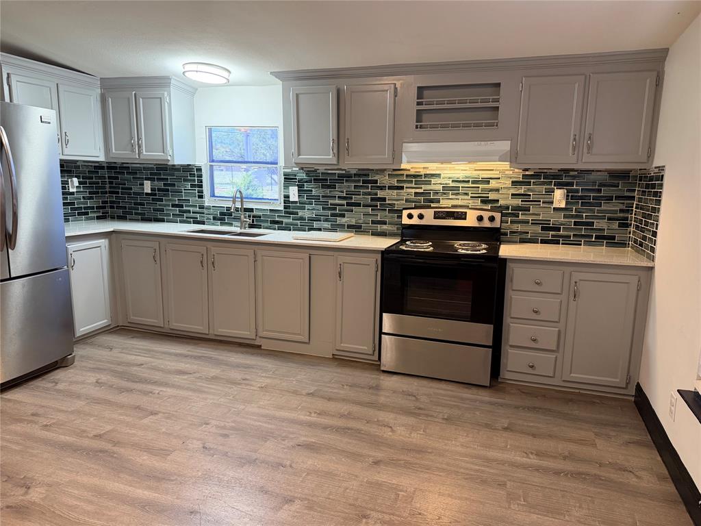 222 Hix Road Cleburne, TX 76031 - Photo 5 of 27 a kitchen with granite countertop a stove sink and cabinets