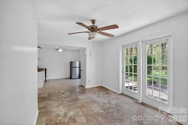 a view of a big room with windows and chandelier fan