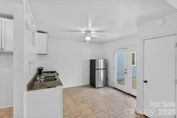 a kitchen with stainless steel appliances a refrigerator a stove a white cabinet and a refrigerator
