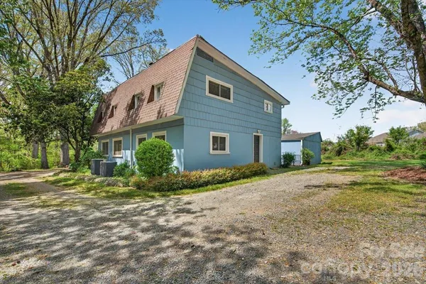 a big yard with lots of green space and trees in the background