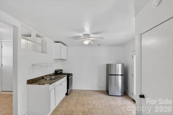 a kitchen with stainless steel appliances granite countertop a refrigerator a stove a microwave and white cabinets