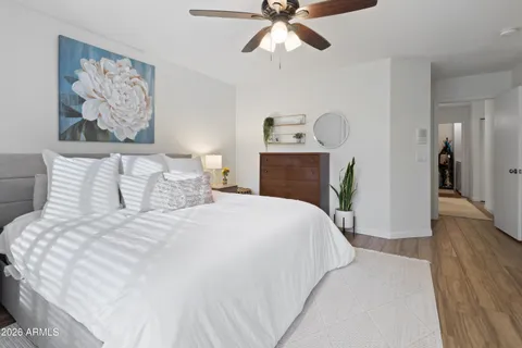 a bedroom with a bed and painting on the wall