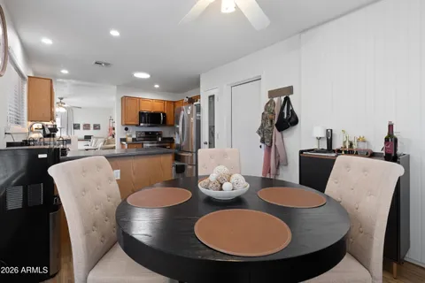 a kitchen with stainless steel appliances granite countertop a sink a stove a dining table and chairs