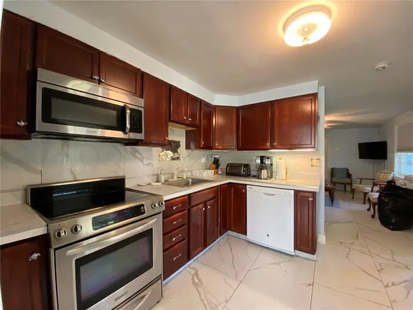 a kitchen with stainless steel appliances granite countertop a stove microwave and sink