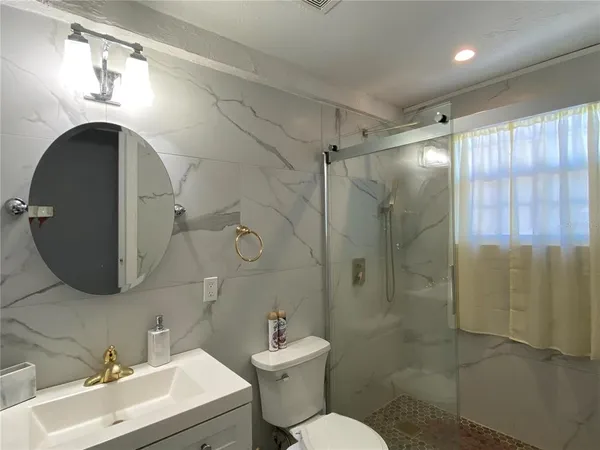 a bathroom with a sink toilet and shower