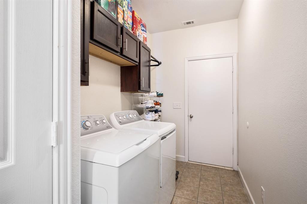 11414 Promenade Road Frisco, TX 75035 - Photo 17 of 24 Laundry area featuring tile flooring, dark wood-finish cabinetry, and a built-in hanging rod