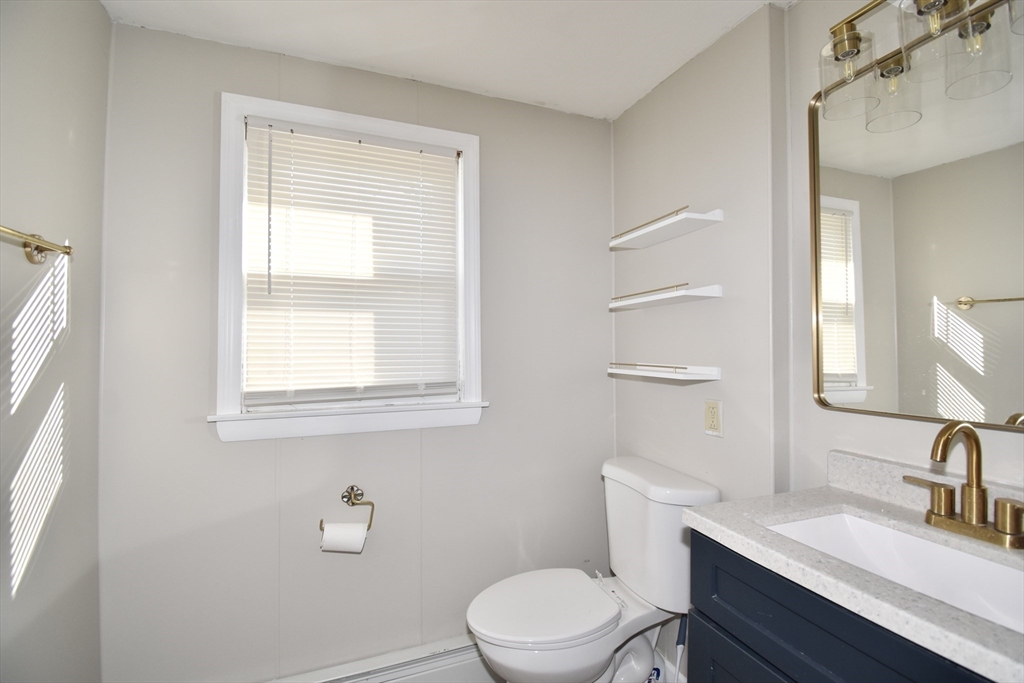 85 Orchard Street Chicopee, MA 01013 - Photo 20 of 33 a bathroom with a toilet a sink a mirror and a window