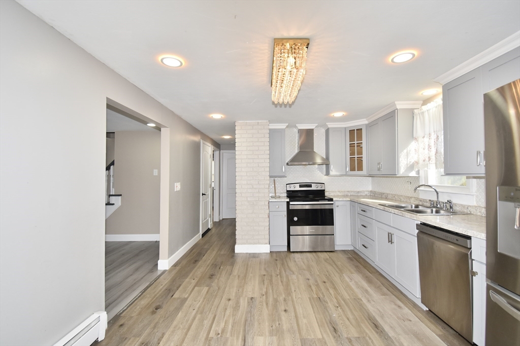 85 Orchard Street Chicopee, MA 01013 - Photo 2 of 33 a large kitchen with a lot of counter space and wooden floor