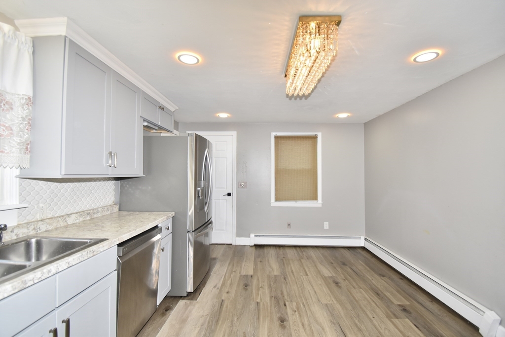 85 Orchard Street Chicopee, MA 01013 - Photo 3 of 33 a kitchen with wooden floors and white cabinets