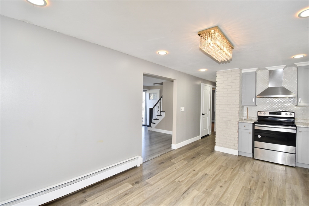 85 Orchard Street Chicopee, MA 01013 - Photo 4 of 33 wooden floor in an empty room and a stove top oven