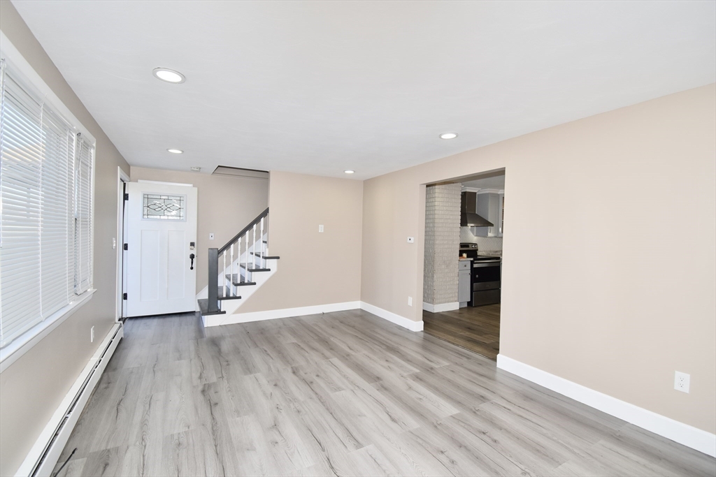 85 Orchard Street Chicopee, MA 01013 - Photo 6 of 33 a view of an empty room with wooden floor and stairs