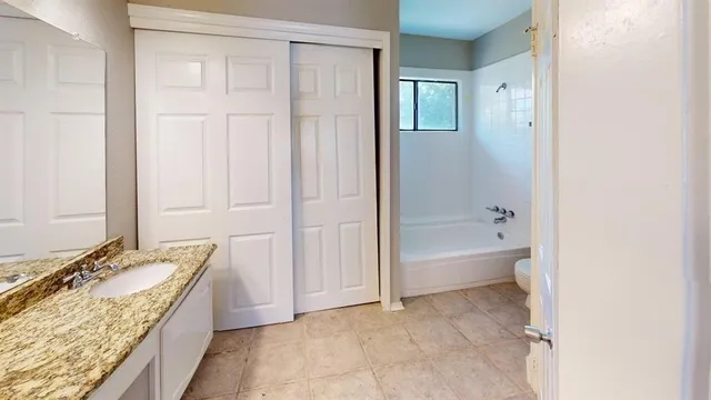 a spacious bathroom with a granite countertop tub sink and mirror