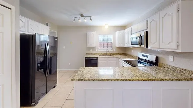 a kitchen with stainless steel appliances granite countertop a refrigerator a stove a sink and a granite counter tops