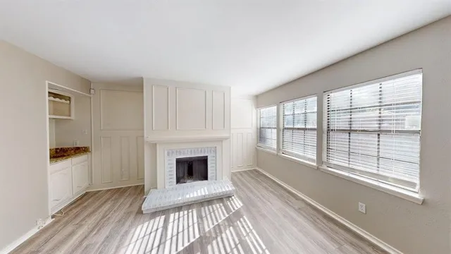 a view of a livingroom with wooden floor and a fireplace