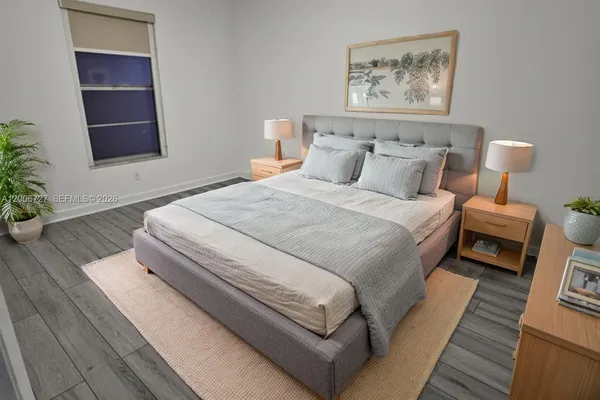 a bed room with a bed and a painting on the wall