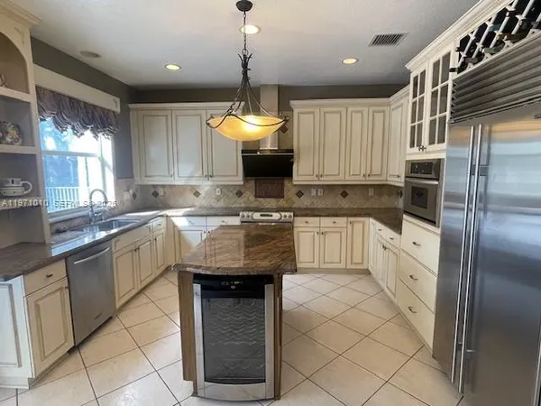 a kitchen with granite countertop a sink stainless steel appliances and cabinets