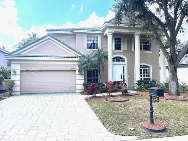 a front view of a house with garden and plants