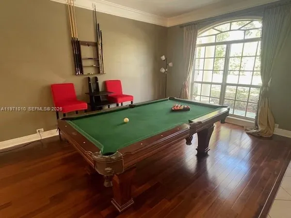 a room with pool table and windows